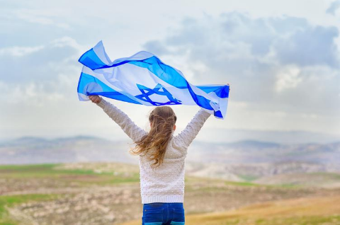 A girl holds an Israeli flag