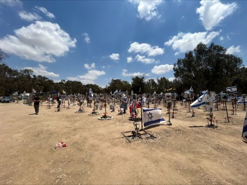 memorials with flowers and Israeli flags at the site of the Nova festival